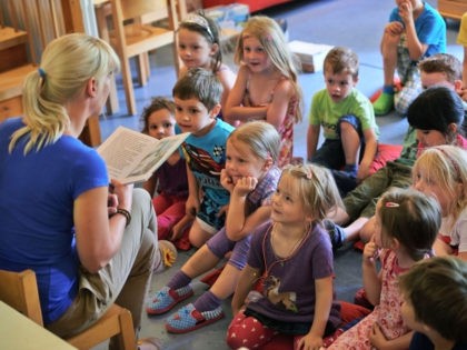PFUNGSTADT, GERMANY - JULY 11: Kindergarten teacher Jennifer Karbot reads a fairy tale about ghosts to her children in a Kindergarten (Kita) on July 11, 2013 in Pfungstadt, Germany. According to numbers which were published by German Family minister Kristina Schroeder, the country reached a family-friendly milestone in boosting the …