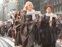 Cuban Americans dressed in black robes carry cross NEW YORK, NY - JULY 13: Cuban Americans dressed in black robes carry crosses as they march down Lexington Avenue in New York 13 July to commemorate the first anniversary of the death of 42 Cubans killed 13 July 1994 on the tugboat "13 de Marzo" as they attempted to …