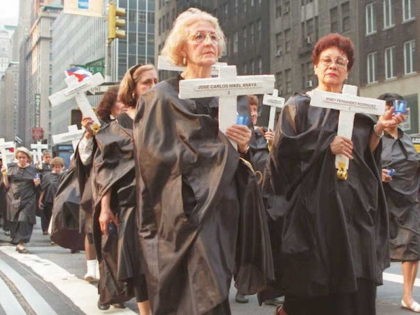 NEW YORK, NY - JULY 13: Cuban Americans dressed in black robes carry crosses as they march down Lexington Avenue in New York 13 July to commemorate the first anniversary of the death of 42 Cubans killed 13 July 1994 on the tugboat "13 de Marzo" as they attempted to …