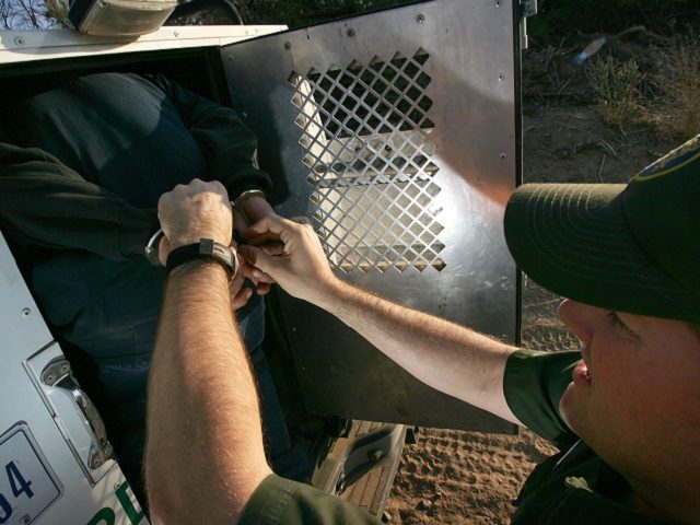 YUMA, AZ - MARCH 17: Handcuffs are removed from a suspected illegal immigrant as he is loaded into the back of a U.S. Customs and Border Protection border patrol vehicle after being apprehended on the California side of the Colorado River on March 17, 2006 near Yuma, Arizona. As Congress …