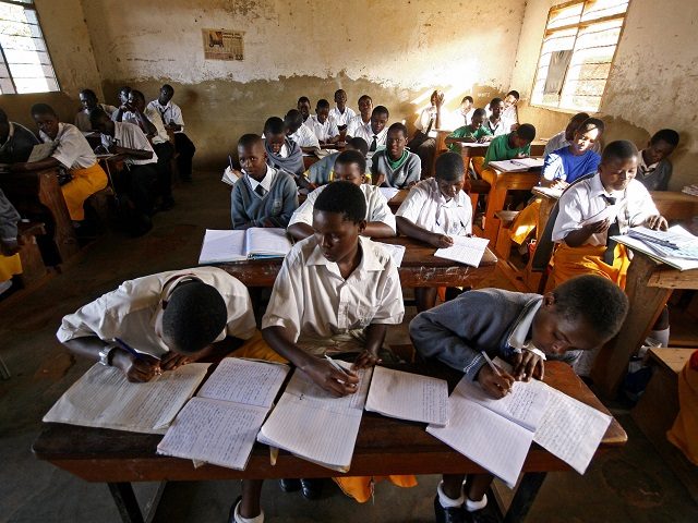 Kampala, UGANDA: Students at St. Denis' Secondary School in Ggaba, a suburb of the capital Kampala, study during the first lesson of the day 23 March 2007. The Ugandan government has recently launched the Universal Secondary Education (USE) programme which enables pupils at certain schools to attend the first year …
