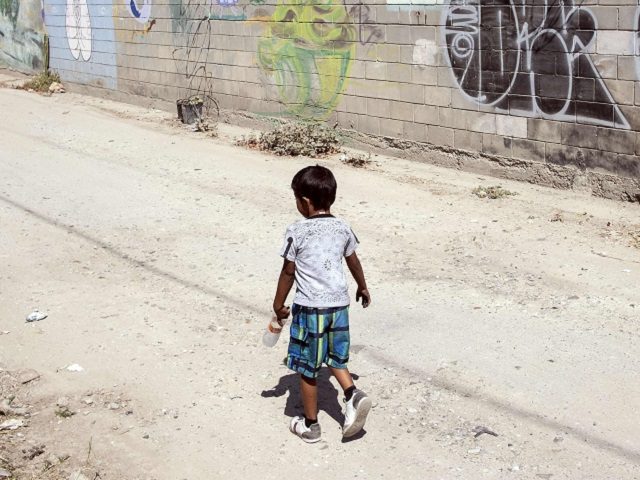 A migrant boy travelling in the "Migrant Via Crucis" caravan, walks along with a
