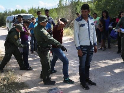 MCALLEN, TX - JUNE 12: U.S. Border Patrol agents take a group of Central American asylum seekers into custody on June 12, 2018 near McAllen, Texas. The immigrant families were then sent to a U.S. Customs and Border Protection (CBP) processing center for possible separation. U.S. border authorities are executing …