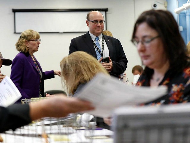 Secretary of State Matt Dunlap oversees the recounting of ballots in Maine's 2nd Congressional District, Thursday, Dec. 6, 2018, in Augusta, Maine. The recount was requested by outgoing U.S. Rep. Bruce Poliquin after losing a November ranked-choice race to Rep.-elect Jared Golden. (AP Photo/Robert F. Bukaty)