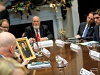 Scarlett Lewis holds up a photo of her son Jesse Lewis, who was killed in the Sandy Hook school shooting, during a meeting with President Donald Trump on the Federal Commission on School Safety report, in the Roosevelt Room of the White House, Tuesday, Dec. 18, 2018, in Washington.