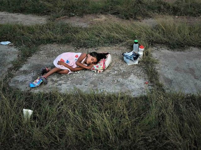 A child sleeps as members of the Central American caravan settle in for the night in an ab