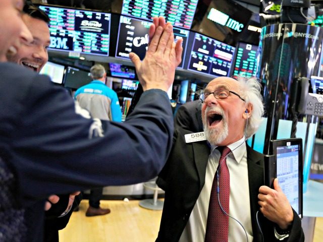 Traders Peter Tuchman, right, slaps a high five before the closing bell on the floor of th