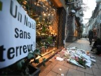 Strasbourg tribute A woman lights a candle in the street next to a message reading 'a Christmas without terror' in tribute to the victims of a deadly shooting two days ago, in central Strasbourg, on December 13, 2018. - Hundreds of French anti-terror police are still hunting for a fugitive gunman who …