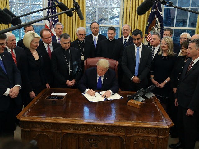 U.S. President Donald Trump signs H.R. 390, the 'Iraq and Syria Genocide Relief and Accountability Act of 2018' in the Oval Office at the White House on December 11, 2018 in Washington, DC. (Photo by Mark Wilson/Getty Images)
