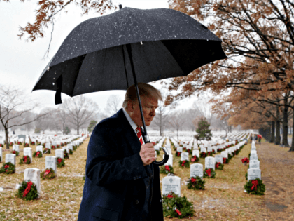 President Donald Trump walks with an umbrella from Section 60 of Arlington National Cemetery in Arlington, Va., Saturday, Dec. 15, 2018, after visiting during Wreaths Across America Day. Wreaths Across America was started in 1992 at Arlington National Cemetery by Maine businessman Morrill Worcester and has expanded to hundreds of …