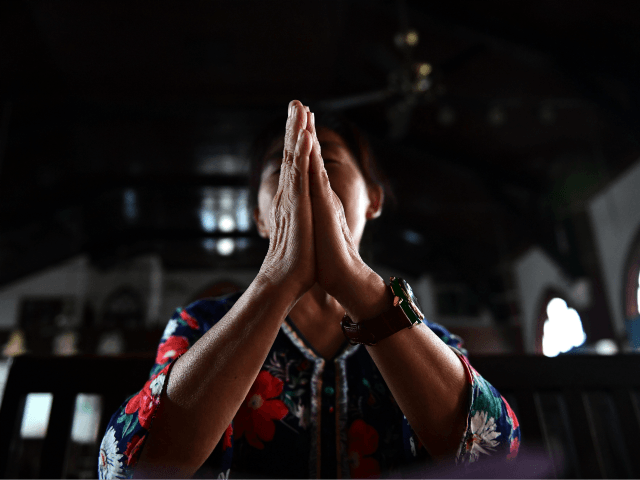A woman prays inside the Christian Glory church in Wuhan on September 23, 2018. - The landmark deal between China and the Vatican is a win for Beijing, giving official recognition to bishops appointed by the government despite a crackdown on religion, and potentially softening the ground for full diplomatic …