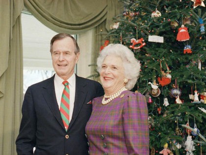 Vice President George H.W. Bush poses with wife Barbara by the White House Christmas tree, Dec., 1988. (AP Photo)