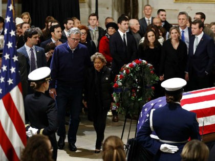 Former Florida Gov. Jeb Bush and his wife Columba approach the flag-draped casket of former President George H.W. Bush as he lies in state in the Capitol's Rotunda in Washington, Tuesday, Dec. 4, 2018. (AP Photo/Patrick Semansky)