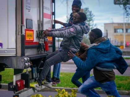 OUISTREHAM, FRANCE - SEPTEMBER 12: Migrants try to board a truck at Ouistreham ferry port in the hope of reaching the UK on September 12, 2018 in Ouistreham, France. After the clamp down at Calais many young migrants are seeking out new routes to the United Kingdom as stowaways on …