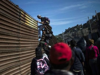 migrants scale border-wall