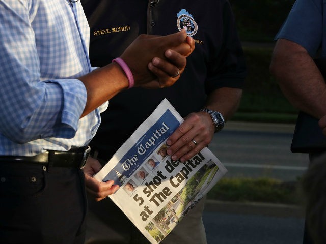 Anne Arundel County Executive Steven Schuh holds today's edition of the Capital Gazette on