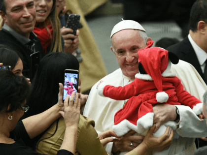 TOPSHOT - Pope Francis holds a baby and poses for photos during an audience for children and families of the Santa Marta dispensary on December 16, 2018 at the Vatican. (Photo by Vincenzo PINTO / AFP) (Photo credit should read VINCENZO PINTO/AFP/Getty Images)