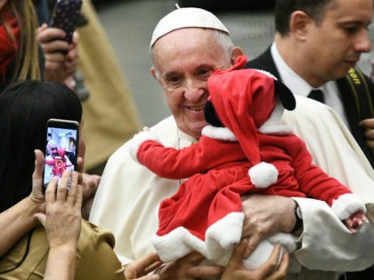 Pope Francis holds a baby wearing a Christmas outfit, and poses for photos during an audience for children and families of the Santa Marta dispensary on December 16, 2018 at the Vatican. (Photo by Vincenzo PINTO / AFP) (Photo credit should read VINCENZO PINTO/AFP/Getty Images)