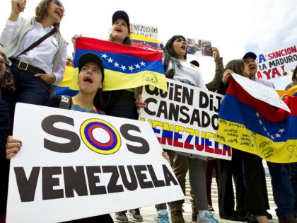 Manifestantes opuestos al gobierno venezolano cantan afuera de la Organización de Estados Americanos (OEA) durante la sesión extraordinaria del Consejo Permanente, en Washington, el lunes 3 de abril de 2017. (AP Foto/José Luis Magana)