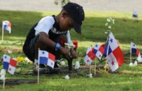 In this 2008 photo, a boy places flowers on the grave of a relative who died in 1989 US invasion of Panama
