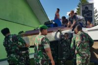 Indonesian soldiers prepare coffins for construction workers believed to have been shot dead