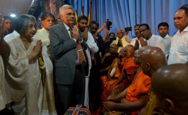 Sri Lanka reinstates ousted PM, begins uneasy truce