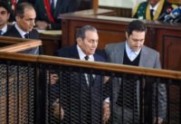 Former Egyptian president Hosni Mubarak (C), who was ousted during a popular uprising in 2011, is escorted by his two sons Alaa (R) and Gamal (L) for a session in the retrial of members of the now-banned Muslim Brotherhood