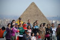 Tourists pose for a group picture at the Giza pyramids on the southwestern outskirts of the Egyptian capital Cairo on December 29, 2018