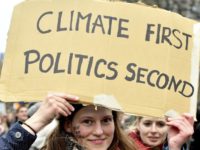 Belgium Climate A demonstrator holds a placard which reads 'climate first, politics second' during a 'Claim the Climate' march in Brussels, Sunday, Dec. 2, 2018. The climate change conference, COP24, will take place in Poland from Dec. 2 14. (AP Photo/Geert Vanden Wijngaert) The Associated Press