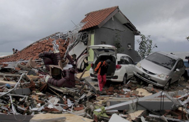 Indonesia Tsunami A man inspects the damage suffered by a building following a tsunami in Anyar, Indonesia, Sunday, Dec. 23, 2018. An eruption of one of the world's most infamous volcanic islands is believed to have triggered a tsunami that killed hundreds of people in Indonesia during a busy holiday weekend. The waves smashed onto beaches at night without warning, ripping houses and hotels from their foundations in seconds and sweeping terrified concertgoers into the sea. (AP Photo) The Associated Press