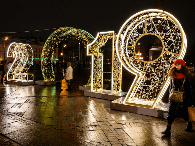 A woman walks in front of an illuminated '2019' sign on a square in central Moscow on Dece