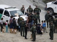 Central America Migrant Caravan U.S. Border Patrol agents process a group of Honduran asylum seekers consisting almost entirely of women and children, after they crossed the U.S. border wall into San Diego, California from Tijuana, Mexico, Monday, Dec. 10, 2018. (AP Photo/Rebecca Blackwell)