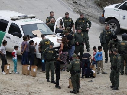 U.S. Border Patrol agents process a group of Honduran asylum seekers consisting almost ent