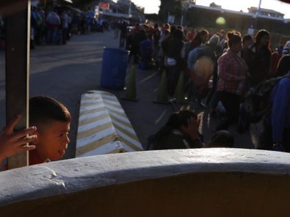 Honduran migrant Fernando, who travels with his parents, waits to cross the border bridge