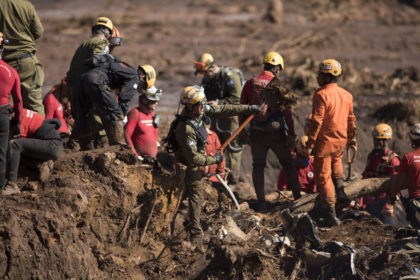 An Israeli rescue specialist, center, works with fellow rescue workers on a site where a b