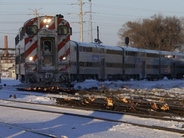 A Metra train moves southbound to downtown Chicago as the gas-fired switch heater on the r