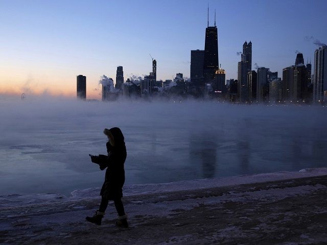A person walks along the lakeshore, Wednesday, Jan. 30, 2019, in Chicago. A deadly arctic deep freeze enveloped the Midwest with record-breaking temperatures on Wednesday, triggering widespread closures of schools and businesses, and prompting the U.S. Postal Service to take the rare step of suspending mail delivery to a wide …