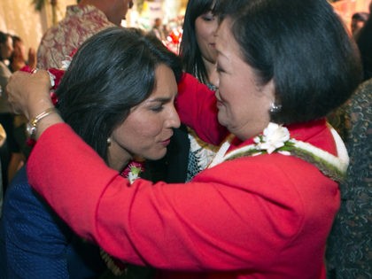 U.S. Rep. Mazie Hirono, right, places a flower lei on candidate Tulsi Gabbard at the Japan