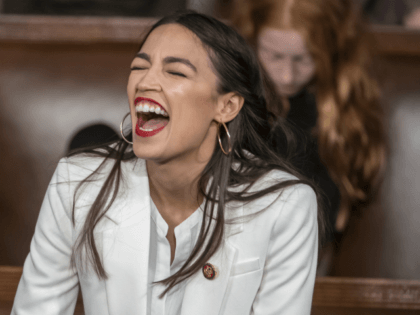Rep. Alexandria Ocasio-Cortez, D-N.Y., laughs out loud as she talks with other new House m