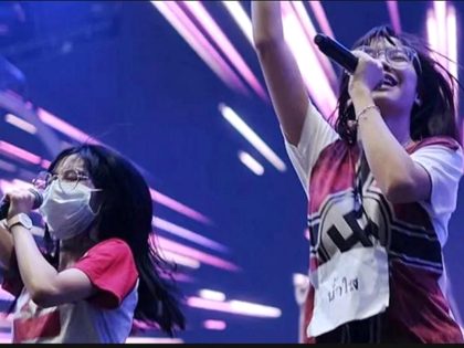 Thai pop band BNK 48 performs on stage dressed in shirts with swastikas.
