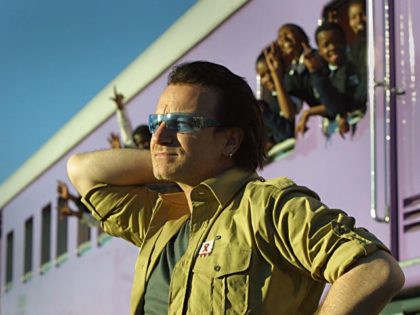 JOHANNESBURG, SOUTH AFRICA: Irish rocker Bono, lead singer of U2 is pictured at the Love Life Train in Soweto township 24 May 2002, outside Johannesburg. He was visiting the clinic that deals with AIDS related issues with the youth of Soweto. Bono is in the country on the second leg …