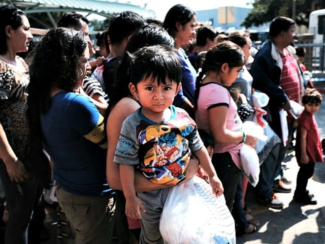 MCALLEN, TX - JUNE 23: Dozens of women, men and their children, many fleeing poverty and violence in Honduras, Guatamala and El Salvador, arrive at a bus station following release from Customs and Border Protection on June 23, 2018 in McAllen, Texas. Once families and individuals are released and given …