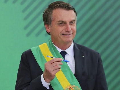 Brazil's new President Jair Bolsonaro poses with the pen used during the swearing-in ceremony for the minsters at the Planalto Palace in Brasilia on January 1, 2019, after his own inauguration at the national Congress. - Bolsonaro takes office with promises to radically change the path taken by Latin America's …