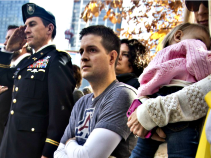 In this Nov. 10, 2014, file photo, former U.S. Air Force Senior Airman Brian Kolfage, center, sits in a wheelchair next to his wife Ashley, right, who holds their daughter Paris, during the National September 11 Memorial and Museum's "Salute to Service" tribute honoring U.S. veterans in New York. Kolfage, …