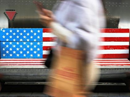In this Sunday, Jan. 6, 2019, photo, a woman walks by a bench painted with the U.S. flag at the capital city's popular shopping mall in Beijing. A U.S. delegation led by deputy U.S. trade representative, Jeffrey D. Gerrish arrived in the Chinese capital for a trade talks with China. …