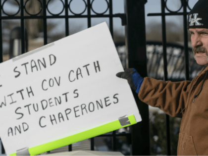 A man places a sign showing support for the students of Covington Catholic Catholic High S