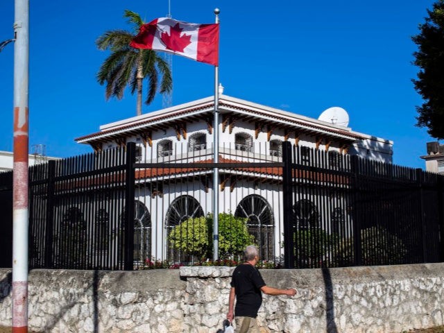 A man walks beside Canada's embassy in Havana, Cuba, Tuesday, April 17, 2018. Canada's foreign ministry said Monday that it is ordering families of diplomatic staff in Cuba to return home amid questions about mysterious health symptoms detected in 10 people who were stationed on the island.