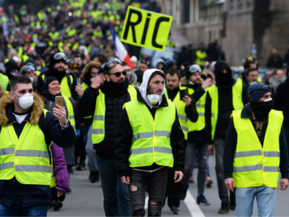 A protester holds a placard reading RIC, the acronym for 'Citizens Initiated Referendum' as he faces police during a 'yellow vest' (gilets jaunes) anti-government demonstration on December 29, 2018, in Nantes, western France. - Police fired tear gas at 'yellow vest' demonstrators in Paris on December 29 but the turnout …