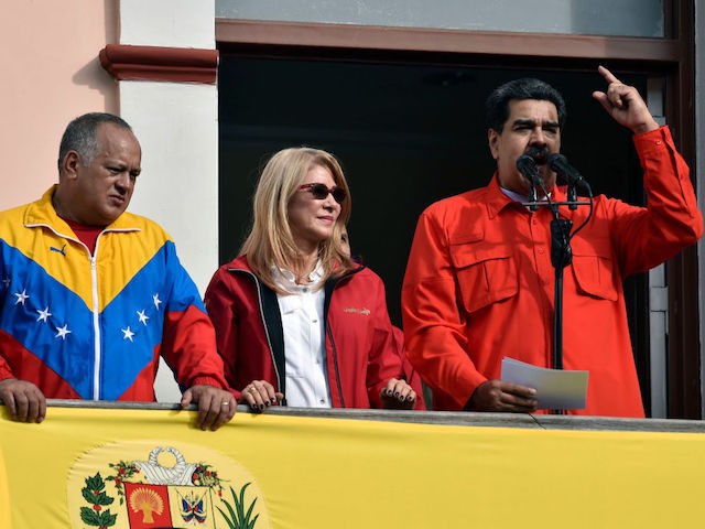 Venezuela's President Nicolas Maduro (R), speaks to a crowd of supporters flanked by his wife Cilia Flores (C) and the head of Venezuela's Constituent Assembly Diosdado Cabello, during a gathering in Caracas on January 23, 2019. - National Assembly head Juan Guaido proclaimed himself Venezuela's "acting president" on Wednesday in …
