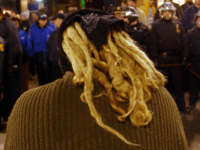 GettyImages-697315 400492 02: An opponent of the World Economic Forum (WEF) stares at police while participating in a anti-WEF march February 2, 2002 in New York City. Thousands of protesters and activists from around the country have descended on New York to rally against the World Economic Forum, a five-day-event in …